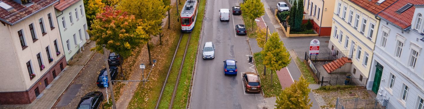 Ansicht Straße mit Autoverkehr und kommender Staßenbahn