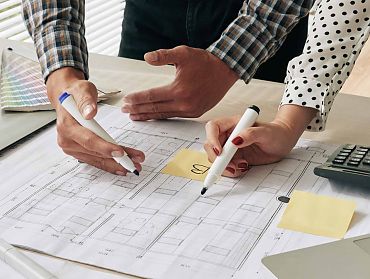 Zwei Personen besprechen und zeichnen ein Projekt